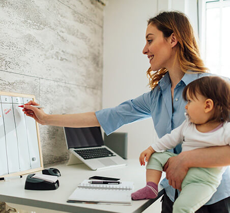 woman with baby writing on calendar