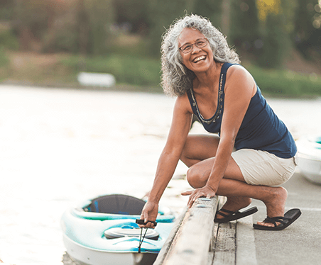 senior woman holding kayak