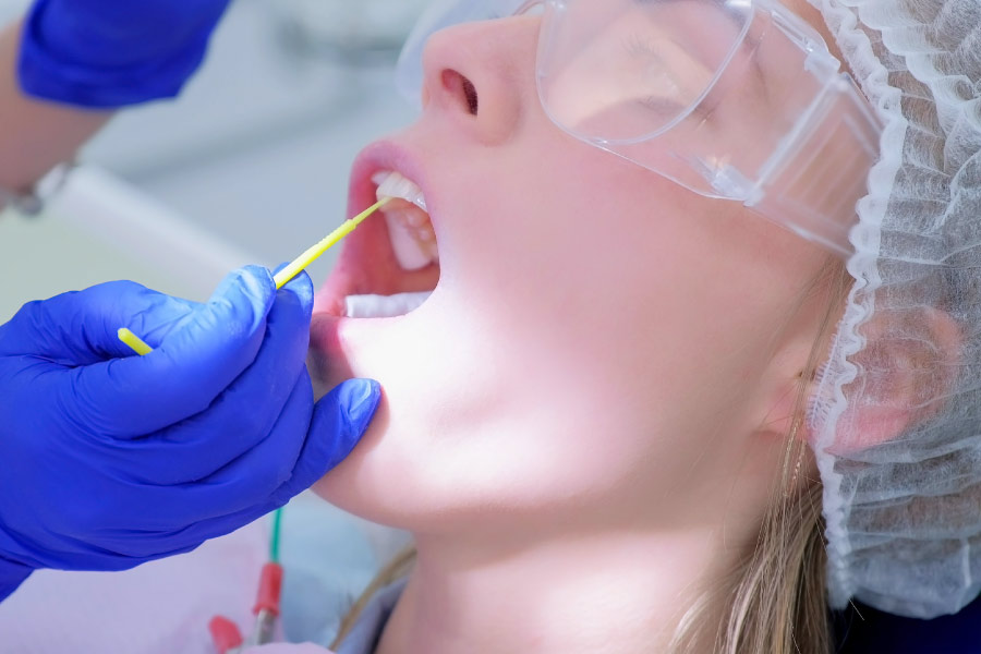 A woman in the dental chair getting a fluoride treatment.