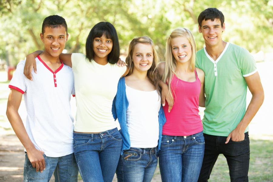 Five smiling teenagers.